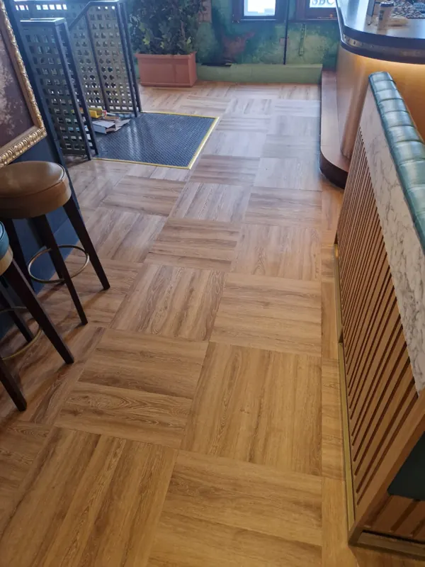 Walkway past the bar stools, finished in parquet-pattern LVT