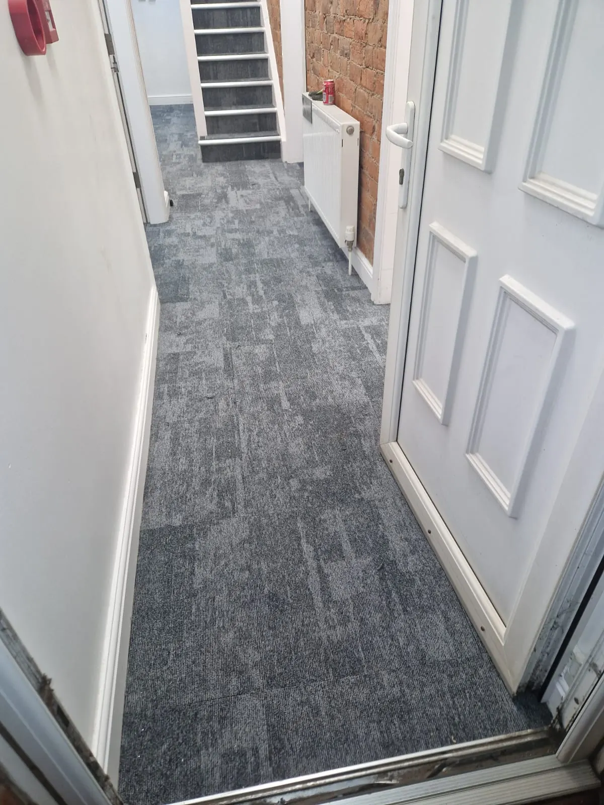Carpet tiles down the corridor towards the stairs