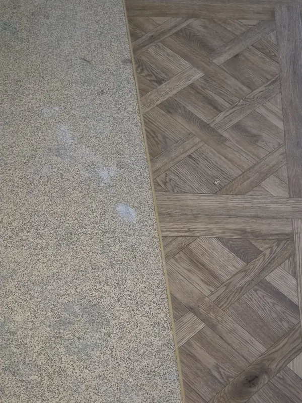 Close-up of the pattern where it meets the existing floor at a threshold strip