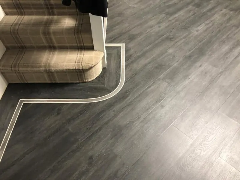 Border strip curving round the bottom stair