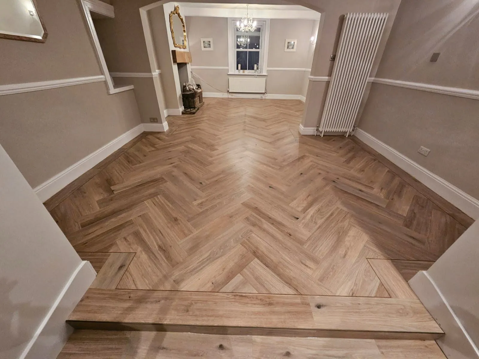 Herringbone LVT through the hall towards the dining room, with a finished step