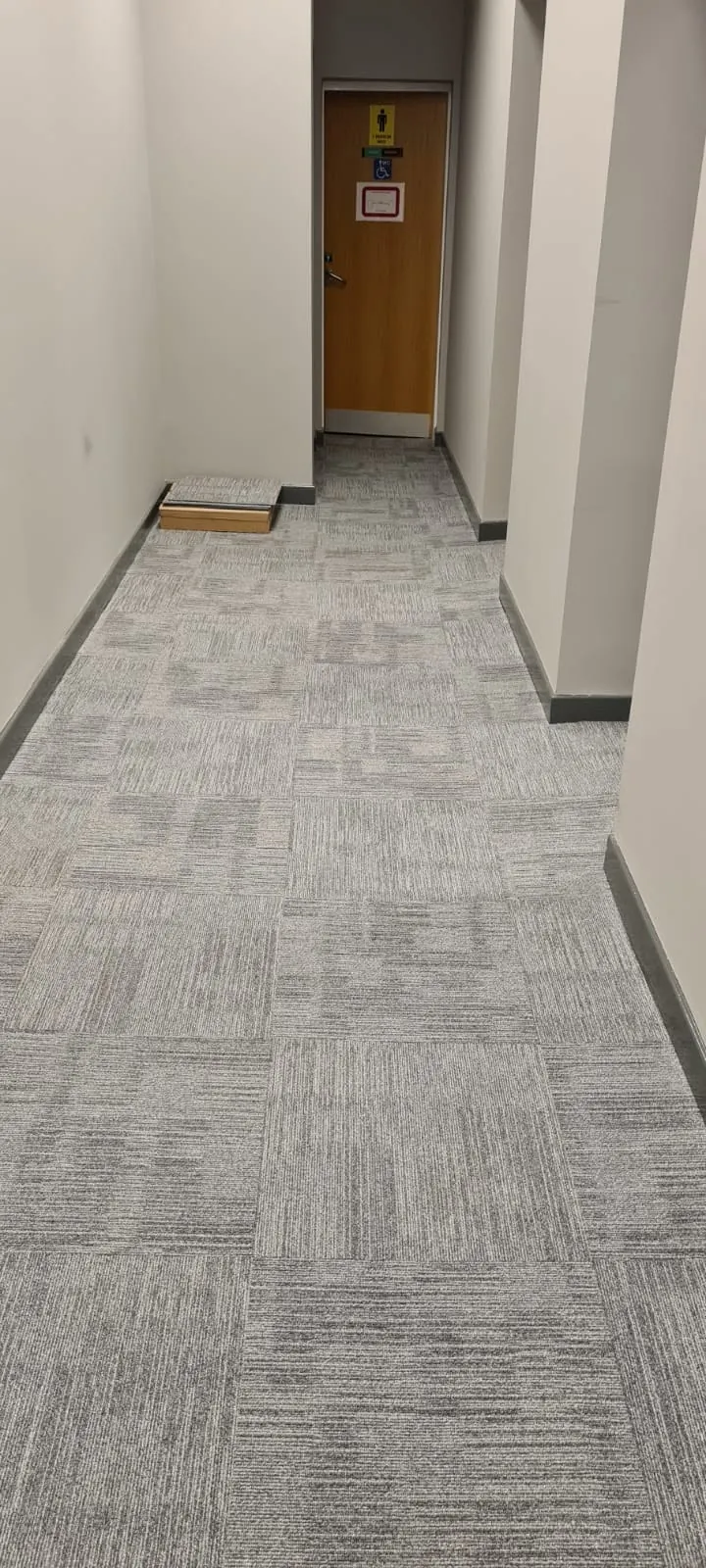 Long office corridor in grey carpet tiles