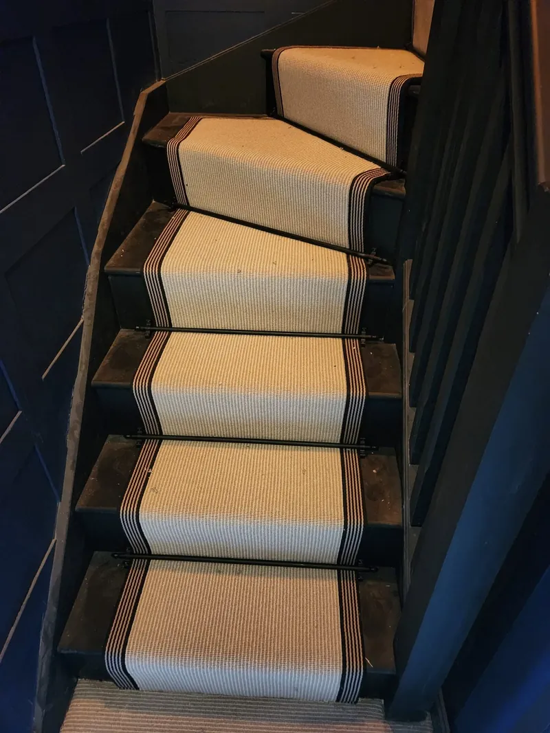 Runner on a painted staircase with timber treads either side